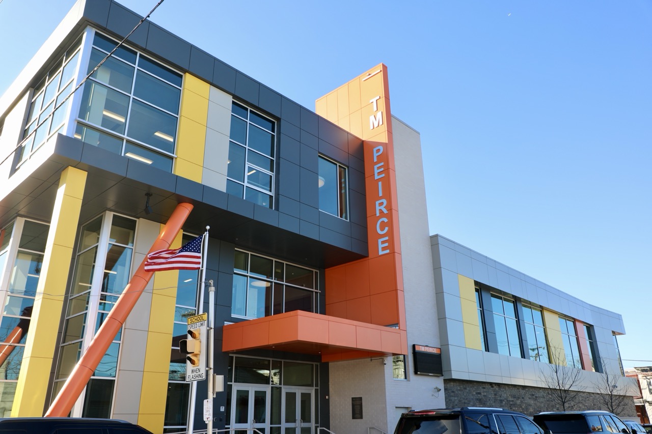 Exterior of the modern Thomas M. Peirce Elementary School building under a clear blue sky.